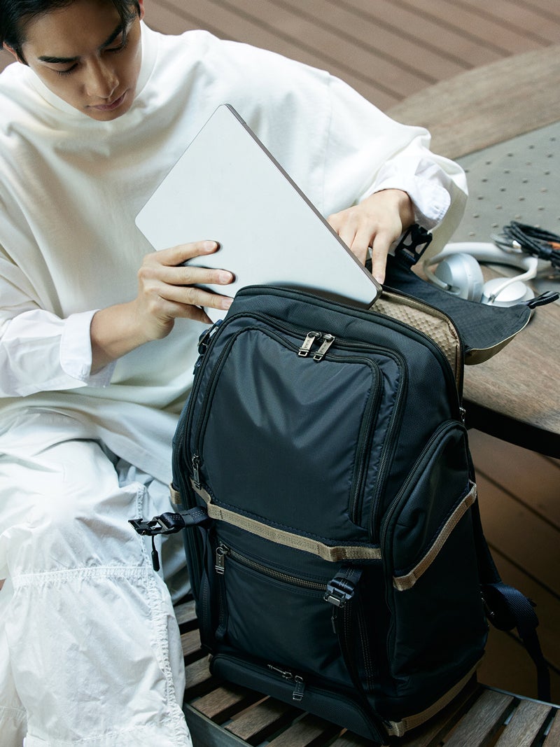TUMIのバックパック「エクスペディション」からノートPCを取り出す俳優の町田啓太さん