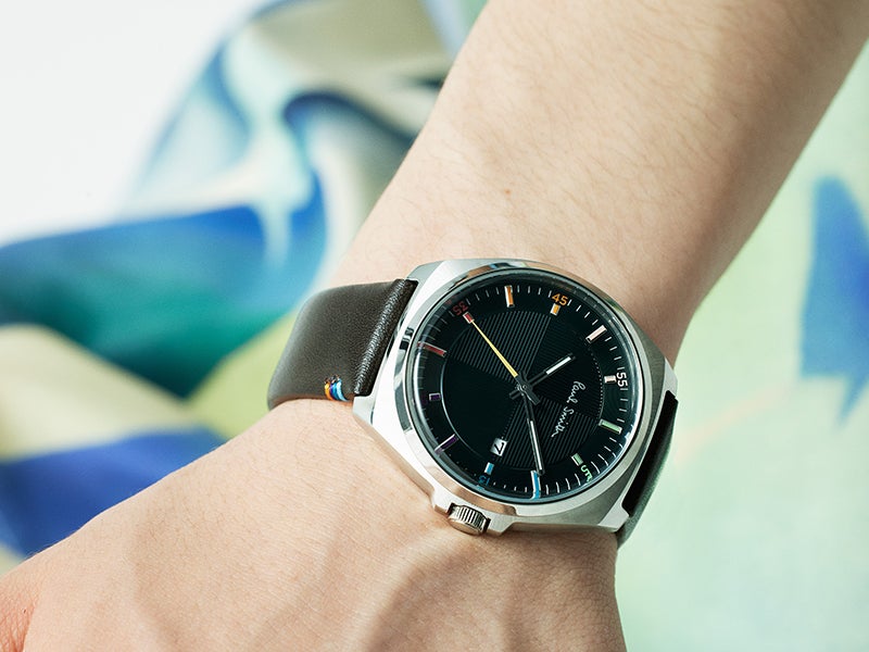 ポール・スミスのメンズ腕時計「クローズド アイズ」のダークグリーンダイヤルモデルを着用した手もとのアップ