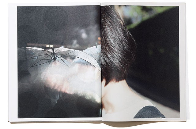 写真集『まほう』川島小鳥。夜の光で輝く傘と、女性の頭のコントラスト