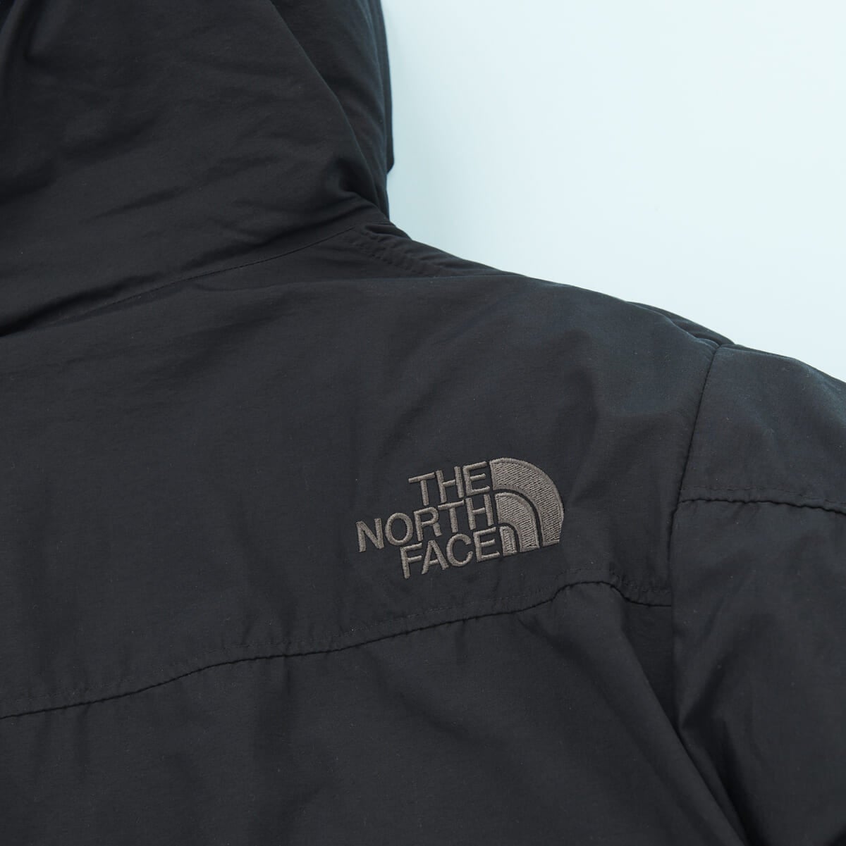 「ザ・ノース・フェイス」の23年冬の新作黒ダウンジャケット「オルタレーションバフズジャケット」の背中のロゴ