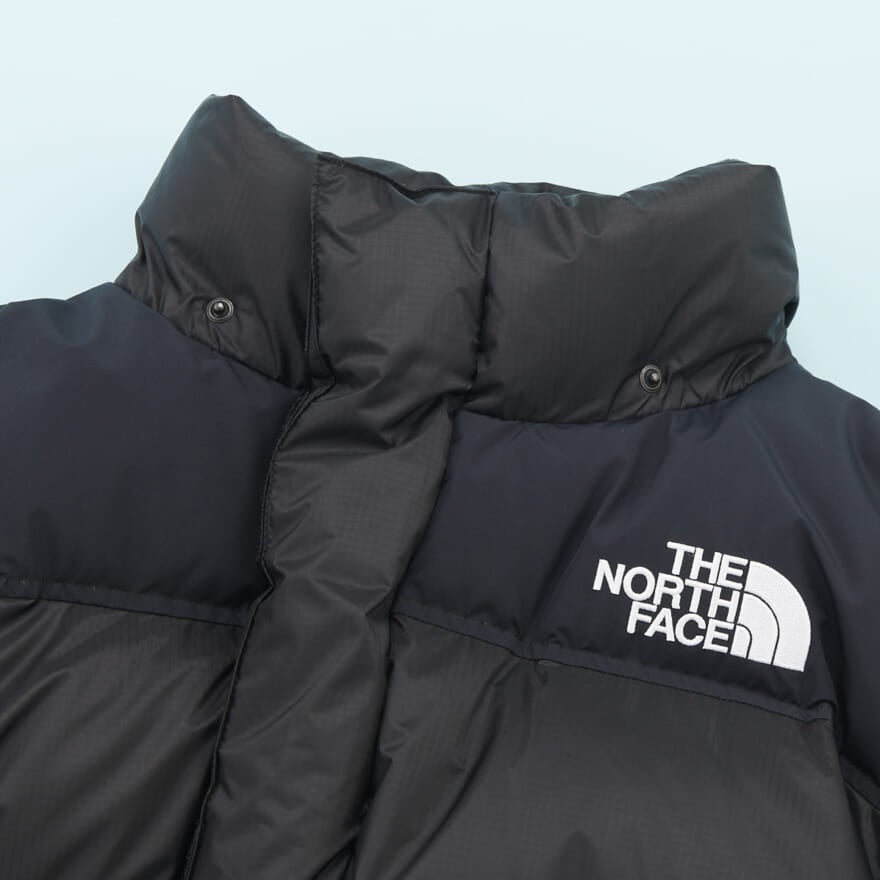 「ザ・ノース・フェイス」の23年冬の新作黒ダウンジャケット「ヒムダウンパーカ」のネック部分とロゴ