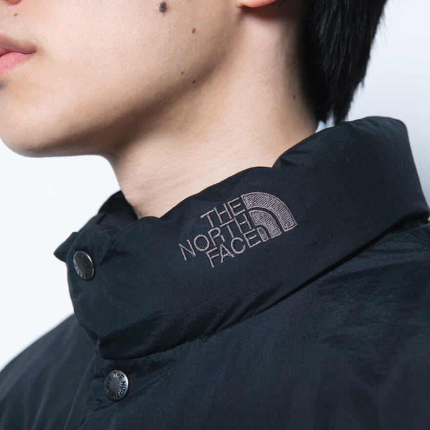 ザ・ノース・フェイスの黒ダウンジャケットの着用カットの首ロゴ