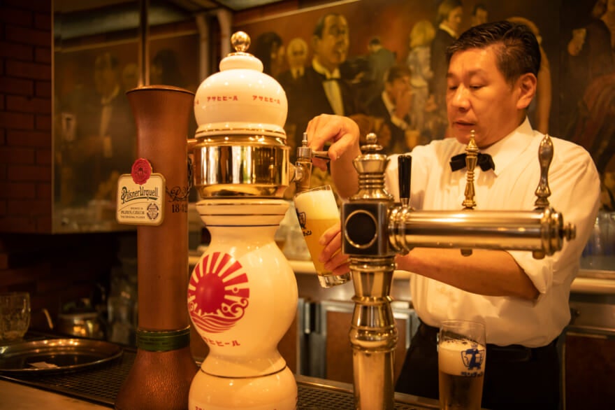 ランチョン ビヤホール ランチョン  神保町 ランチ ディナー ビール 稲井孝太朗　四代目マスター 鈴木寛さん　ビールを注ぐ様子　カウンター　マルエフ