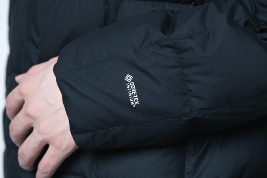 モンベルの黒ダウン「U.L.トラベルダウン コート」の着用カット　ゴアテックスロゴ