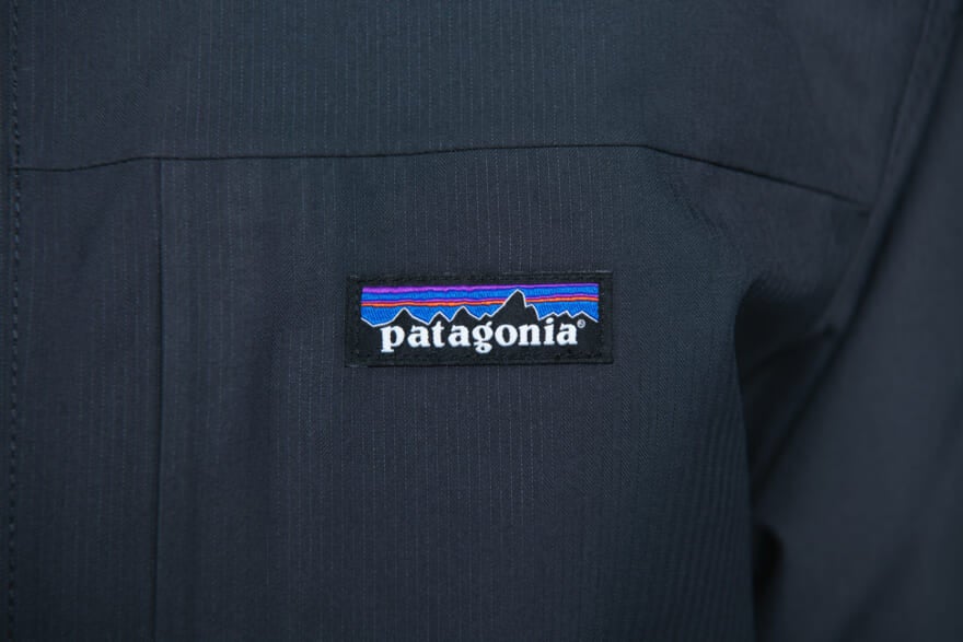 パタゴニアの黒ダウン「メンズ・トレス・スリーインワン・パーカ」の着用画像のロゴ