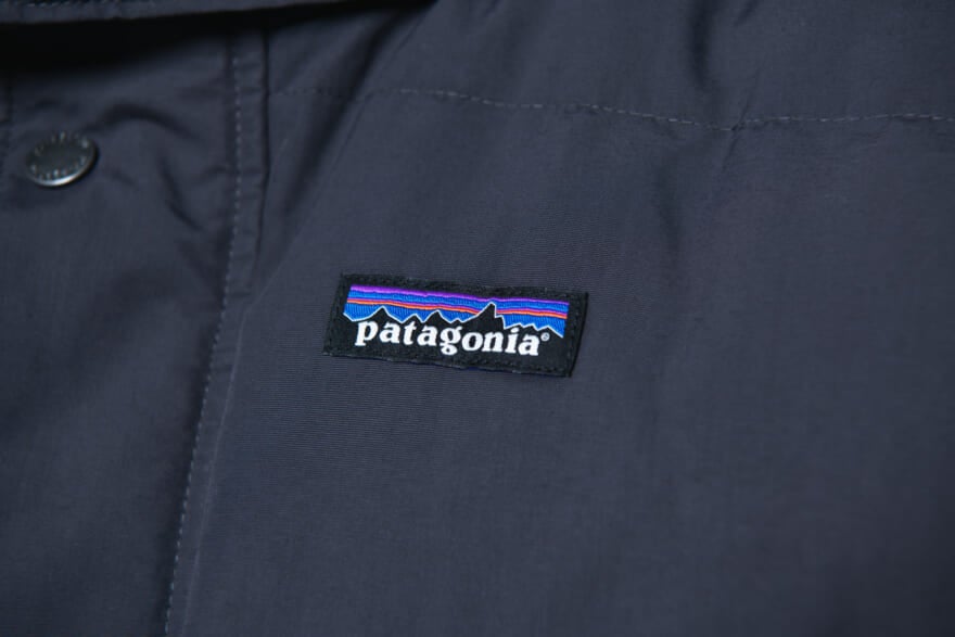 パタゴニアの黒ダウン「メンズ・ダウンドリフト・ジャケット」の着用画像　ロゴ寄り