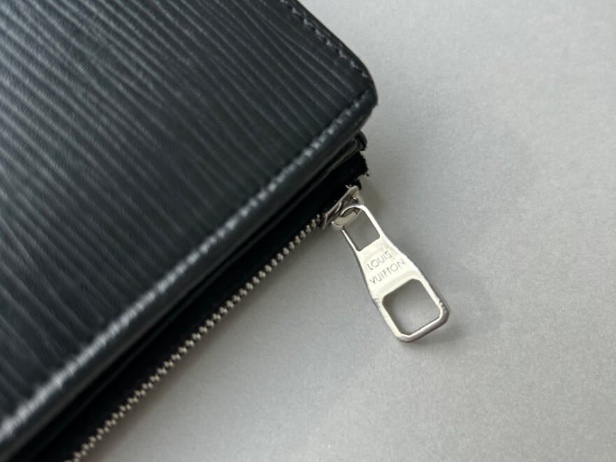 エディター愛用のルイ・ヴィトンの黒いレザー財布のジップ