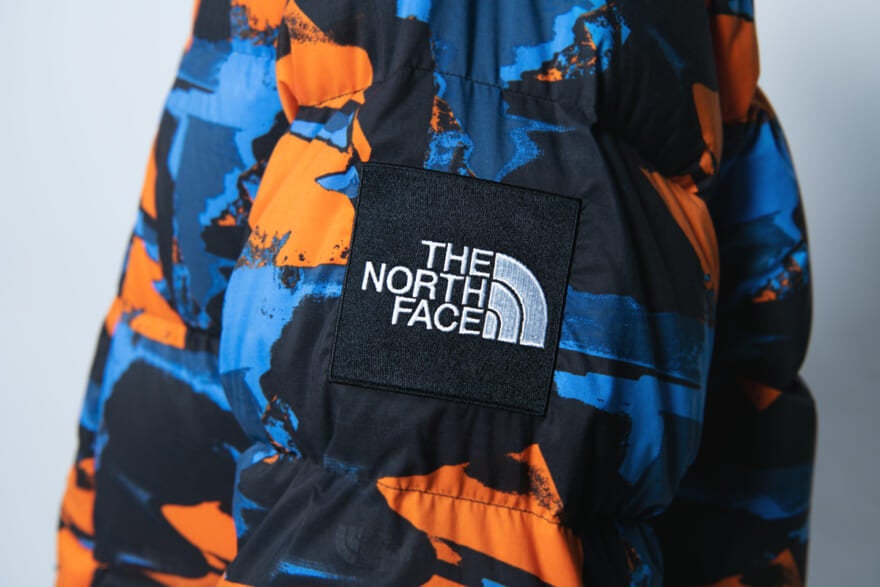 ザ・ノース・フェイスのダウン「ノベルティキャンプシエラショート」のモデル着用カット　ロゴ
