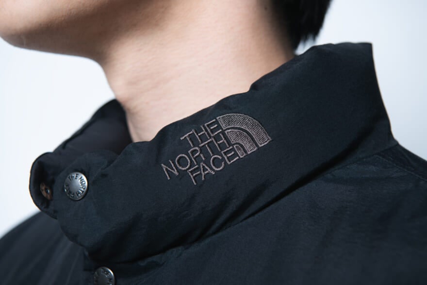 ザ・ノース・フェイスのダウン「オルタレーションシエラジャケット」のモデル着用カット　ネック部分のロゴ