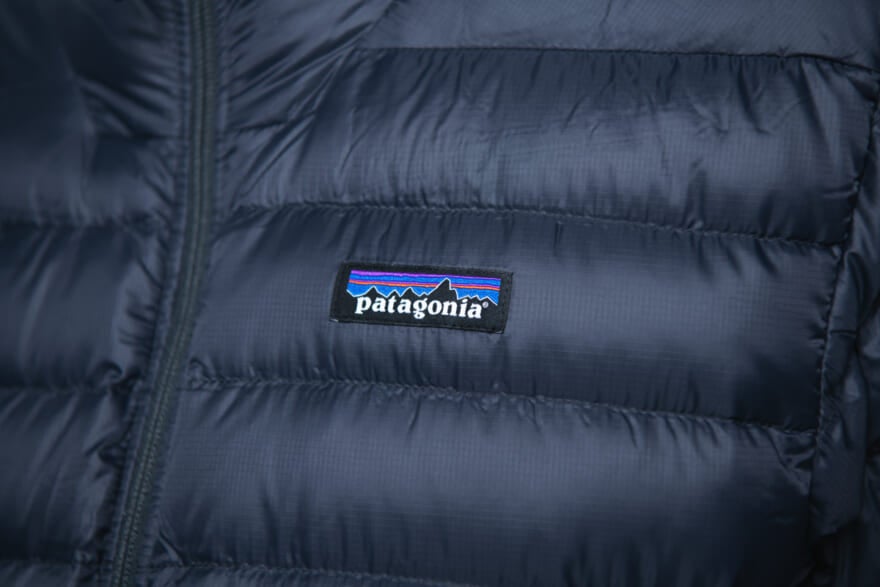 パタゴニアの黒ダウン「メンズ・ダウン・セーター」の着用画像のロゴ