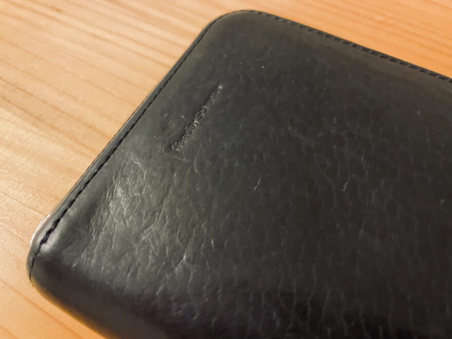 エディター愛用のエンダースキーマの黒いレザー財布のロゴ
