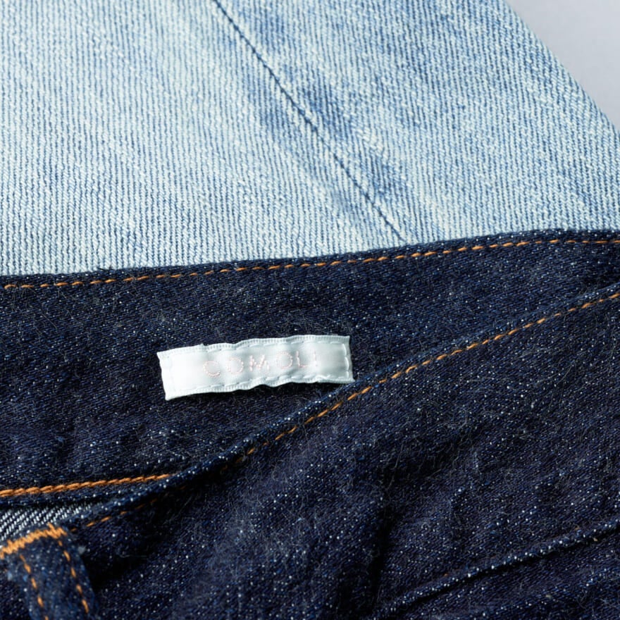 COMOLI DENIM 5P PANTSのネイビーのブランドロゴ