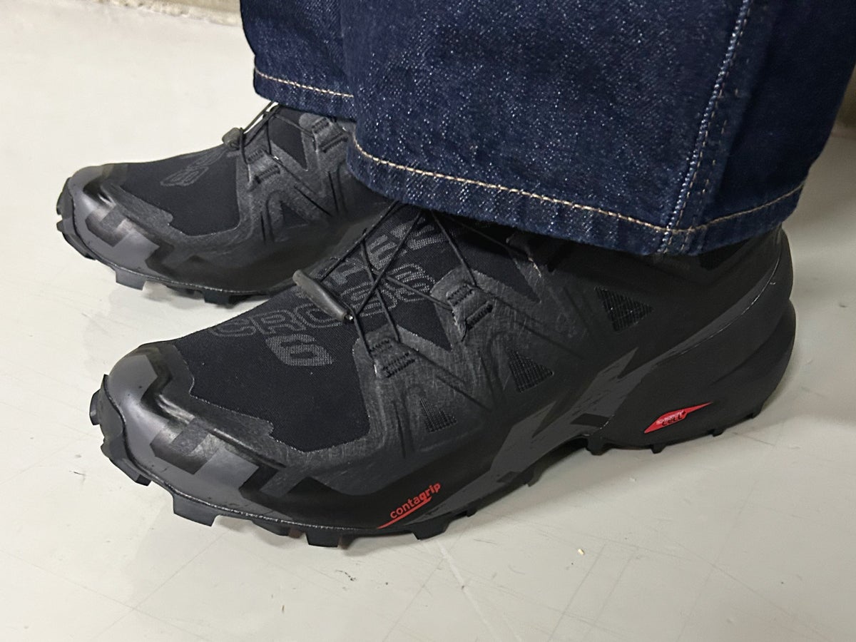 エル・エル・ビーンの黒いレインジャケットのオシャレな着こなし サロモンの黒スニーカー サイド