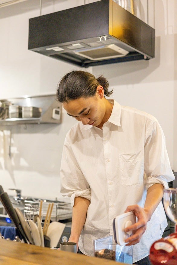 カフェのキッチンでコーヒーを入れる安西一真