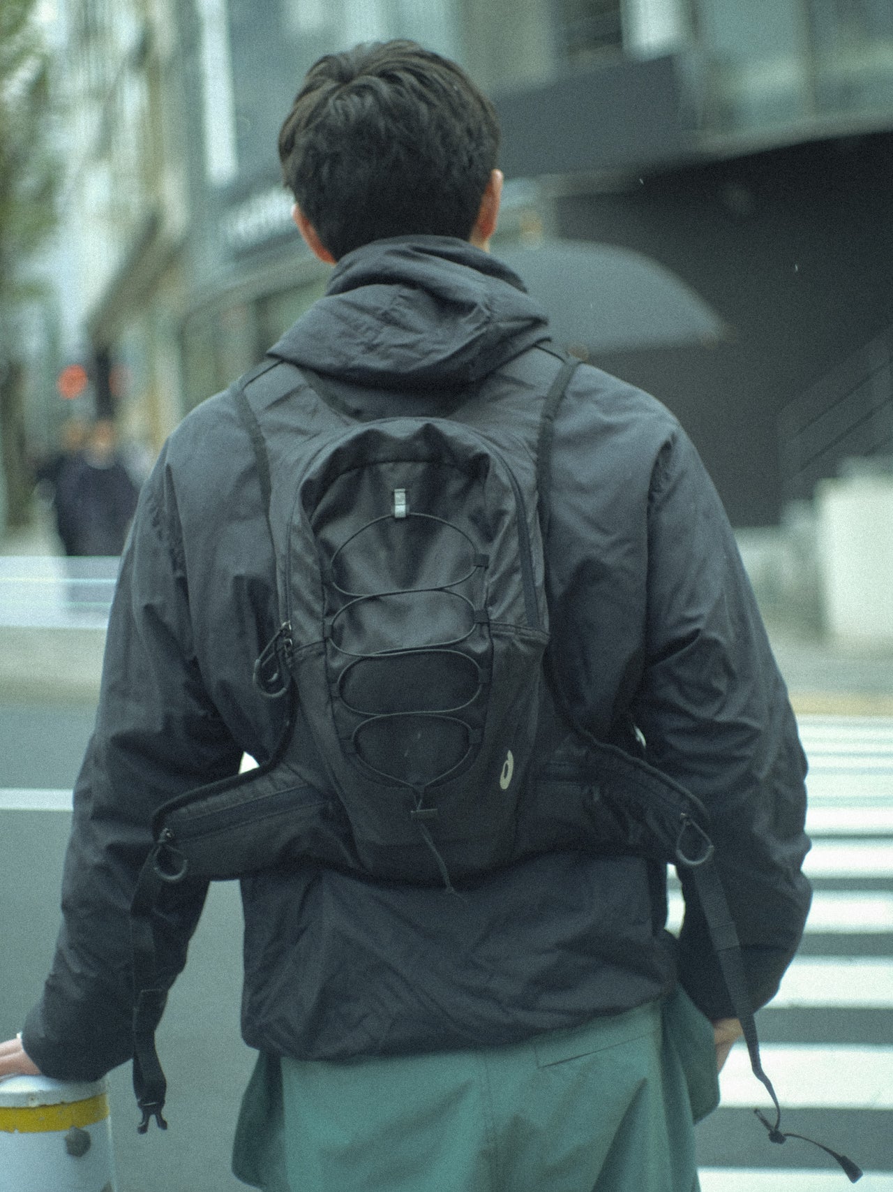 アシックスの黒いバッグジャケット
