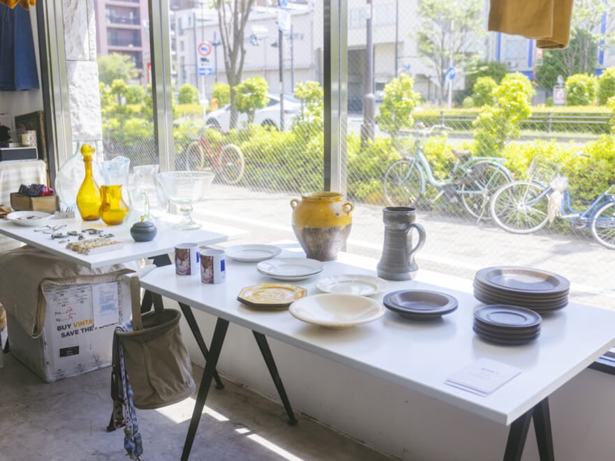 店舗の中の棚の一部。食器などのアイテムが机の上に置かれている。プロが推す東京の古着屋「sinot」
