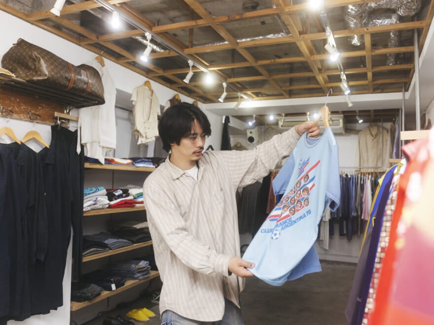 青いTシャツを手に持つ中道さん