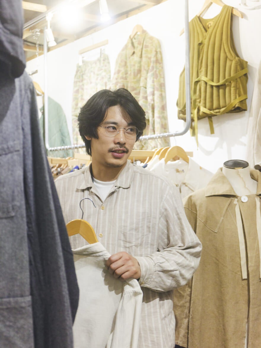 ヴィンテージがエリアで服に囲まれる中道さん