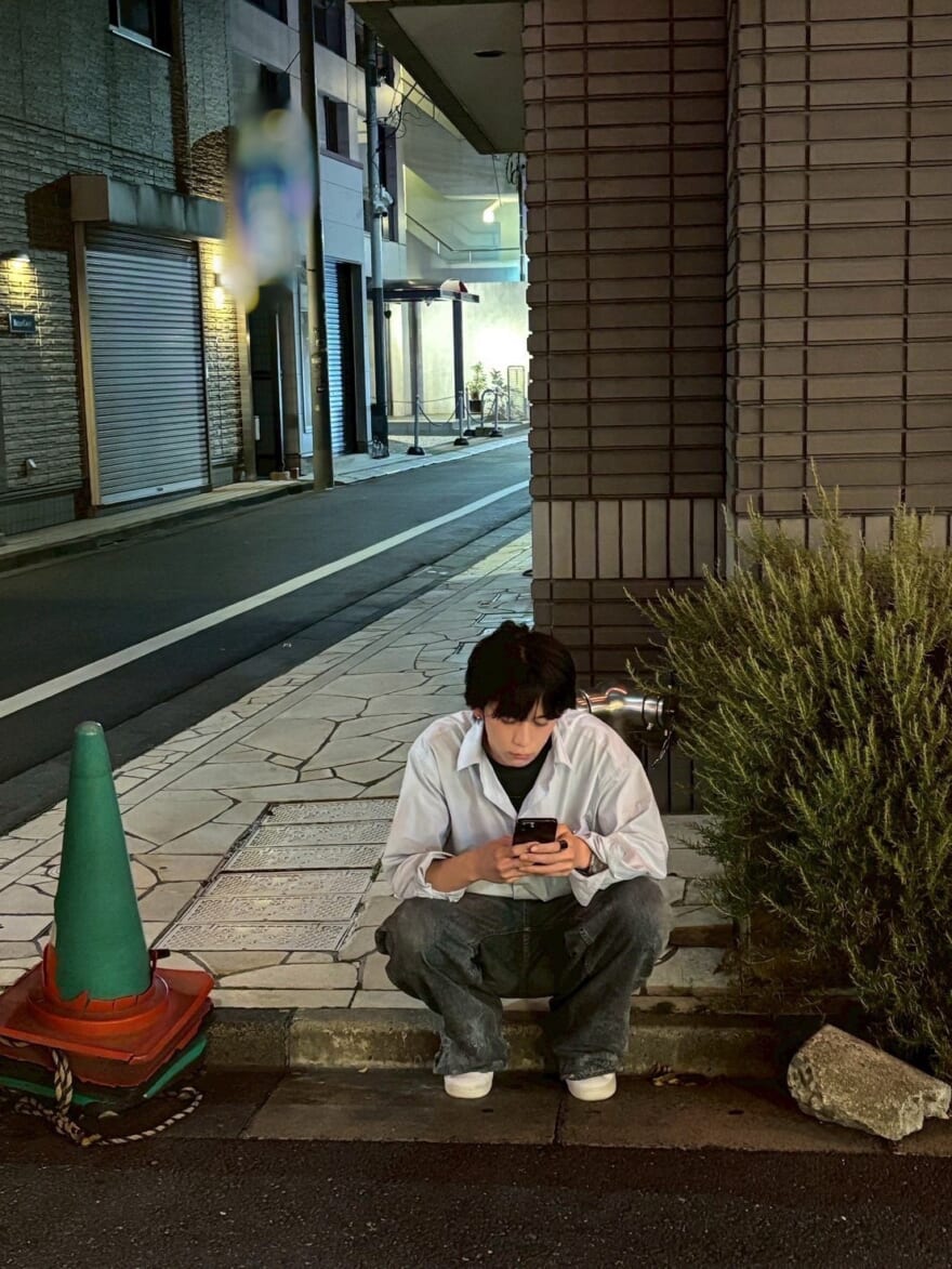 道にしゃがむ小方蒼介