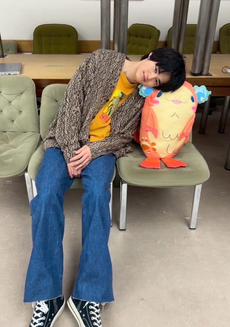 「チャオ」のぬいぐるみに体を預ける鈴鹿央士