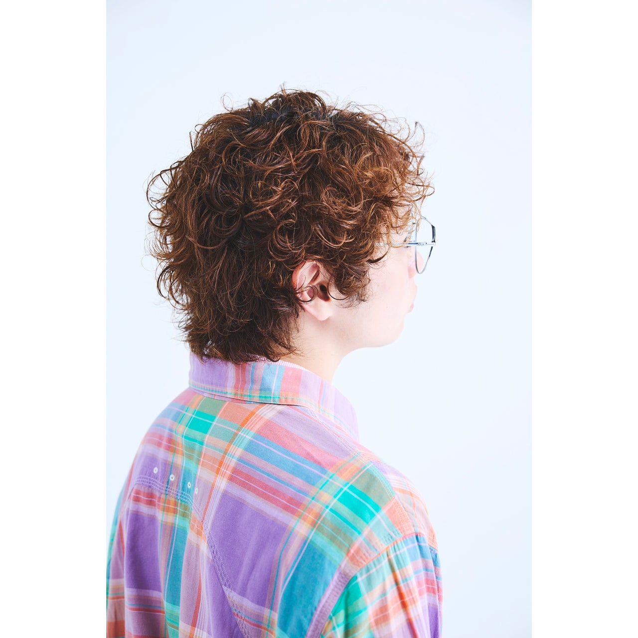 明るいブラウンのヘアカラーとパーマスタイルに合わせた、男性の洋服のコーディネート３
