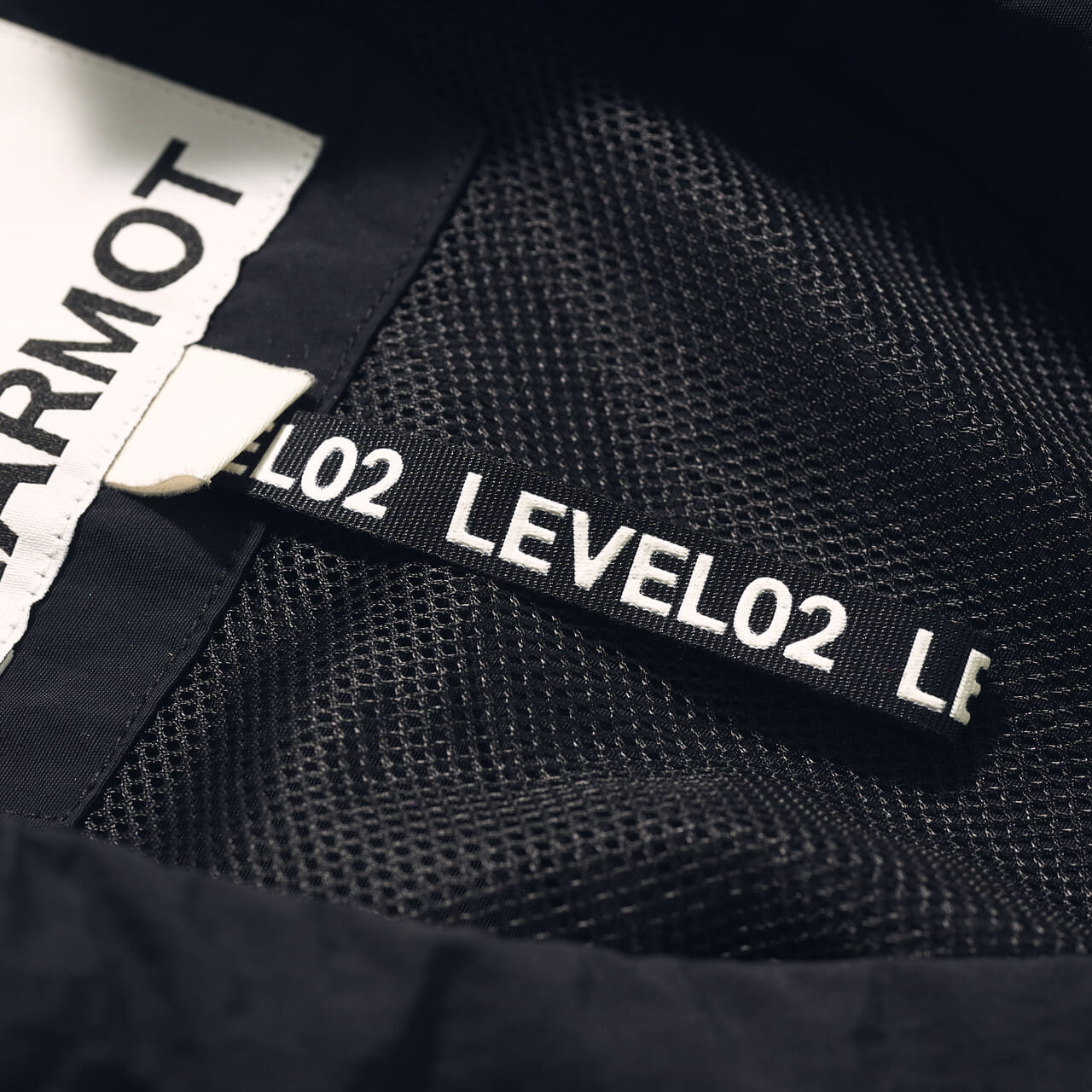 エディターが愛用するMARMOT CAPITALの黒ベスト「CURVE STITCH NYLON VEST」のタグ