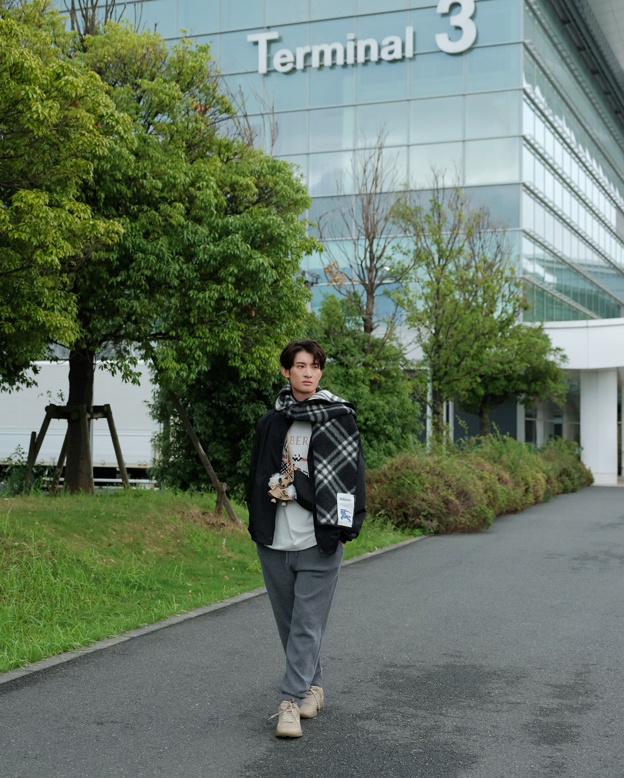 2026年9月20日、バーバリーを着用して羽田空港第３ターミナル前に立つSnow Manの向井康二さん
