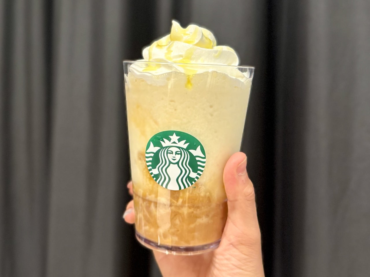 スタバ新作2025秋メニュー「洋なし 生キャラメル フラペチーノ」を手に持った様子