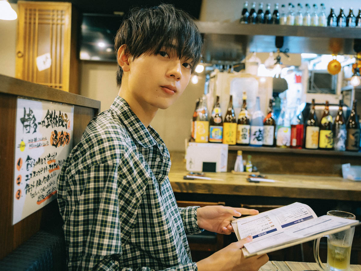 居酒屋でメニューを見る水沢林太郎