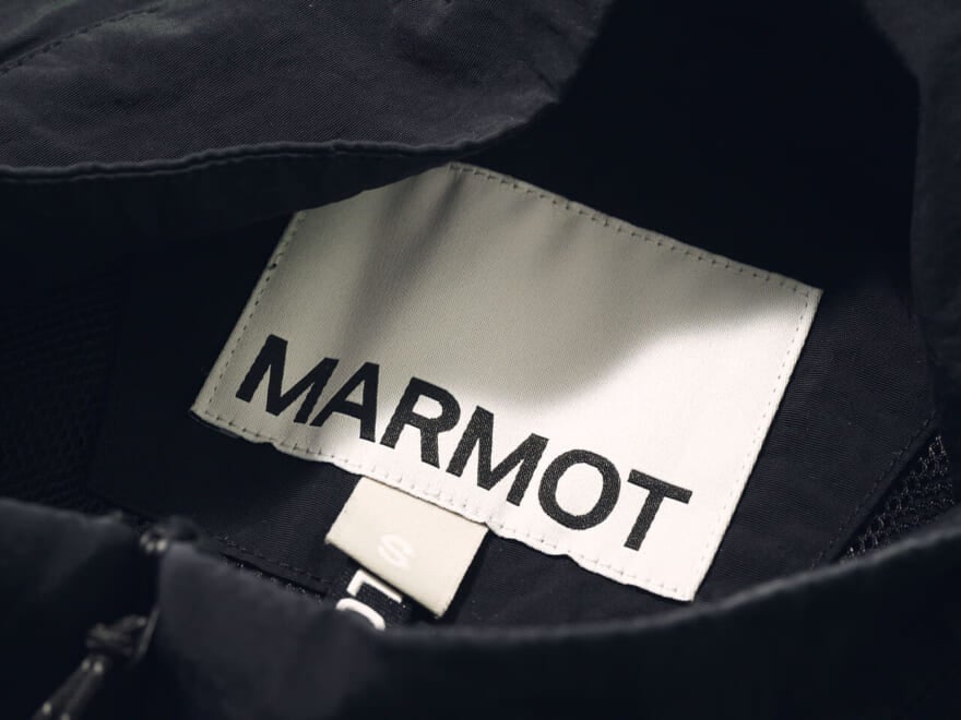 エディターが愛用するMARMOT CAPITALの黒ベスト「CURVE STITCH NYLON VEST」のタグ