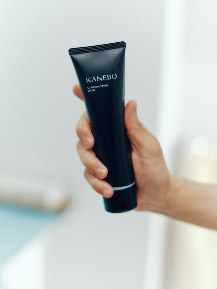 KANEBOの洗顔料「スクラビングマッドウォッシュ」を手に持つ男性