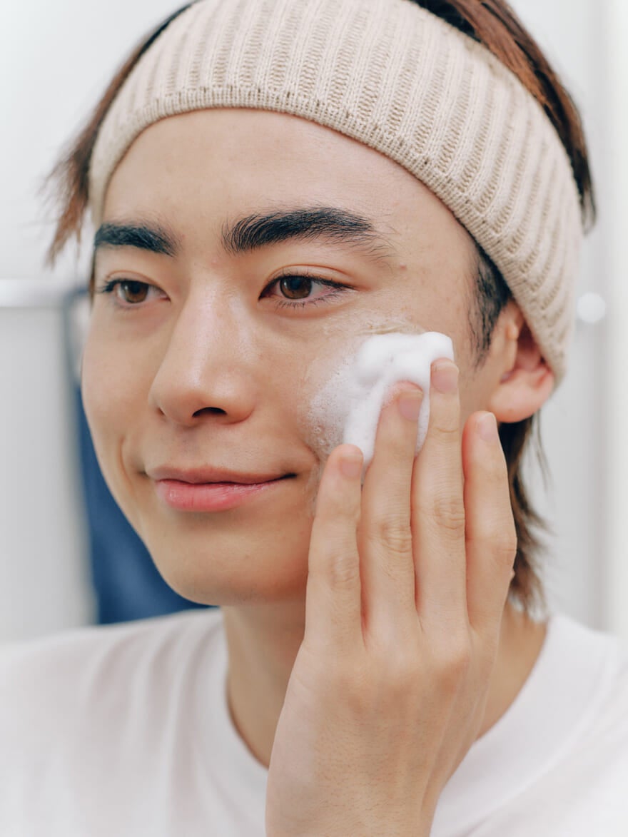 顔に塗った「スクラビングマッドウォッシュ」に水分を含ませて泡立てる豊田裕大