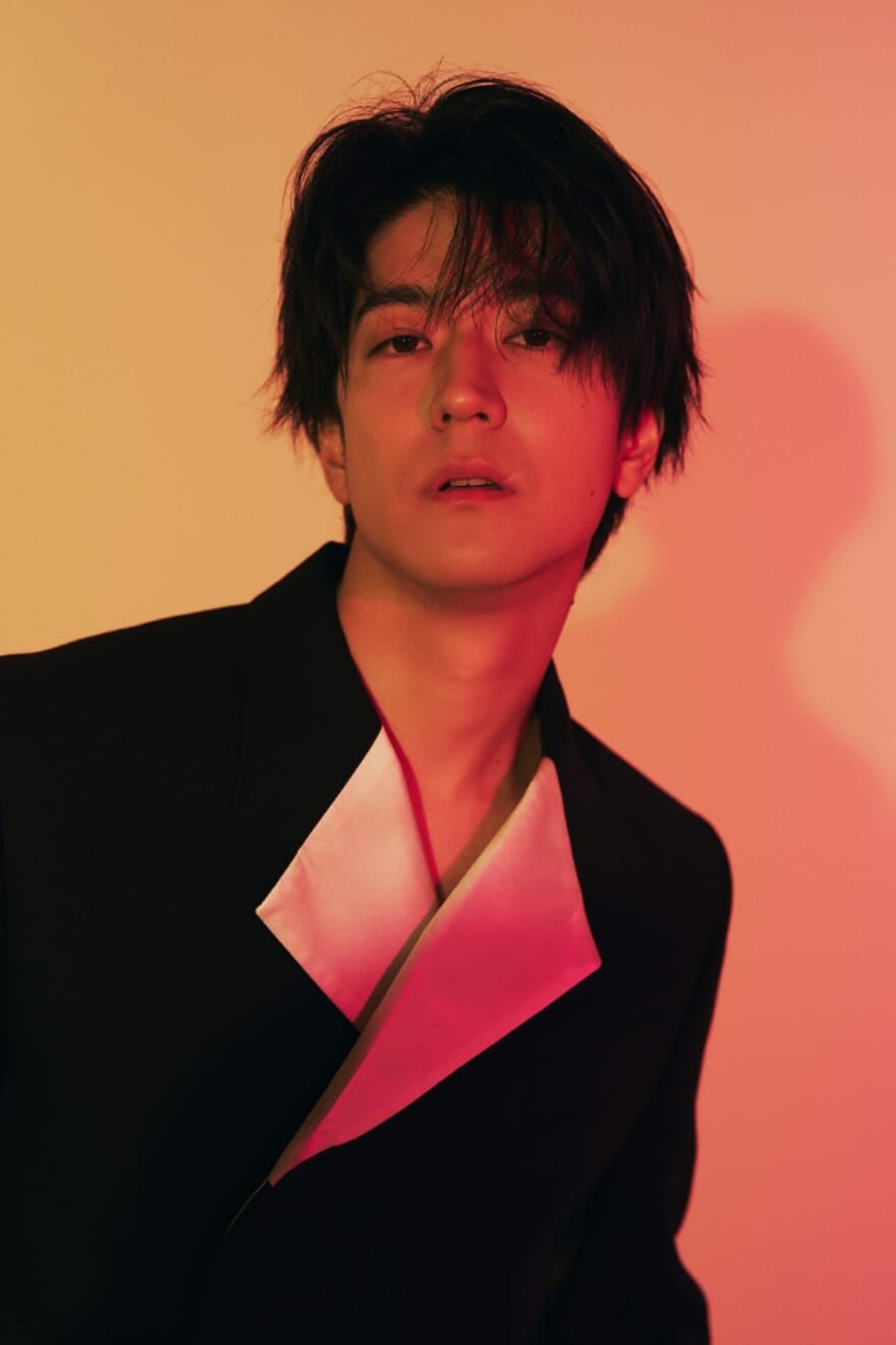 中島裕翔さんのメンズノンノ限定公開ショット。赤いライトに照らされている。