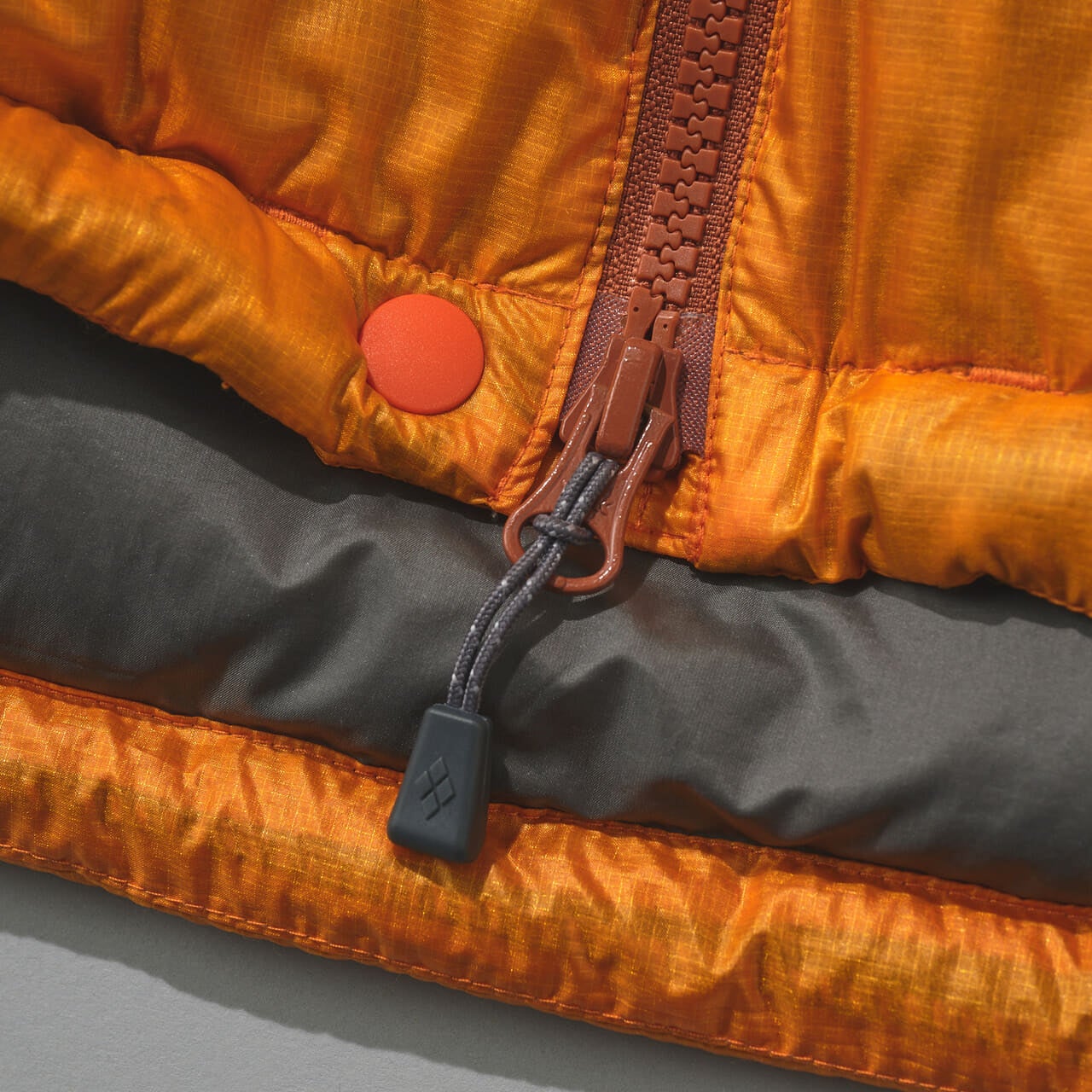 モンベルのアルパインダウン パーカの裾のスナップボタン