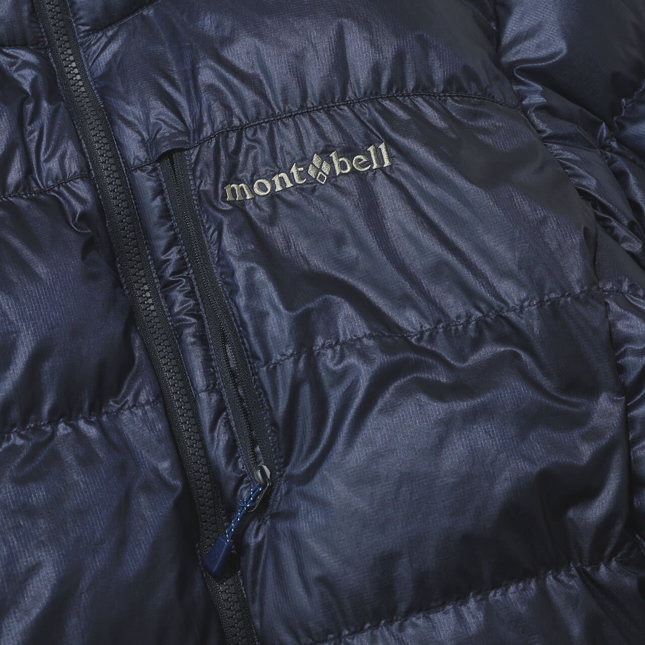 モンベルのアルパインダウン ジャケットの胸ポケットとブランドロゴ