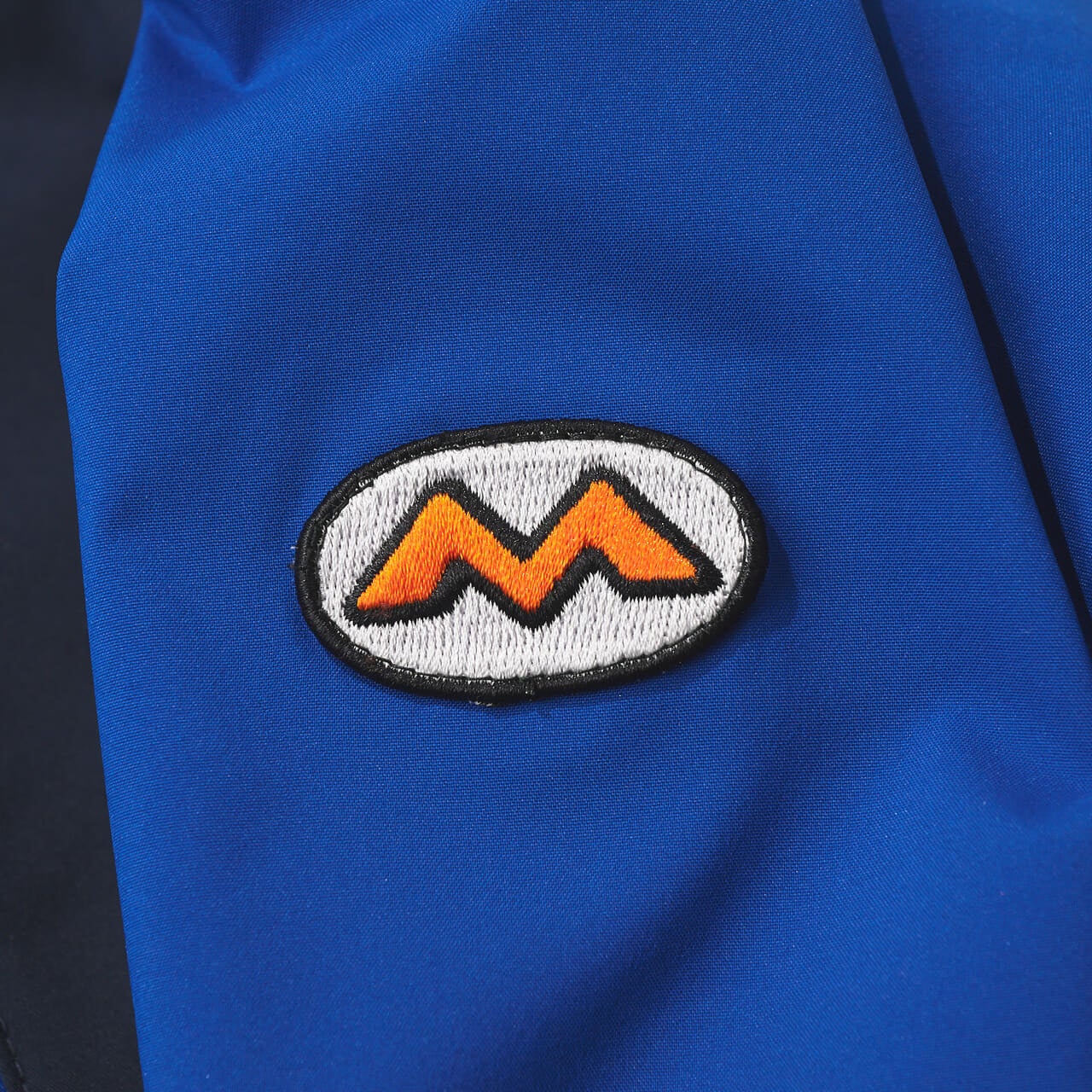 モンベルの50th スーパードリューパーカ の袖のオーバルロゴ