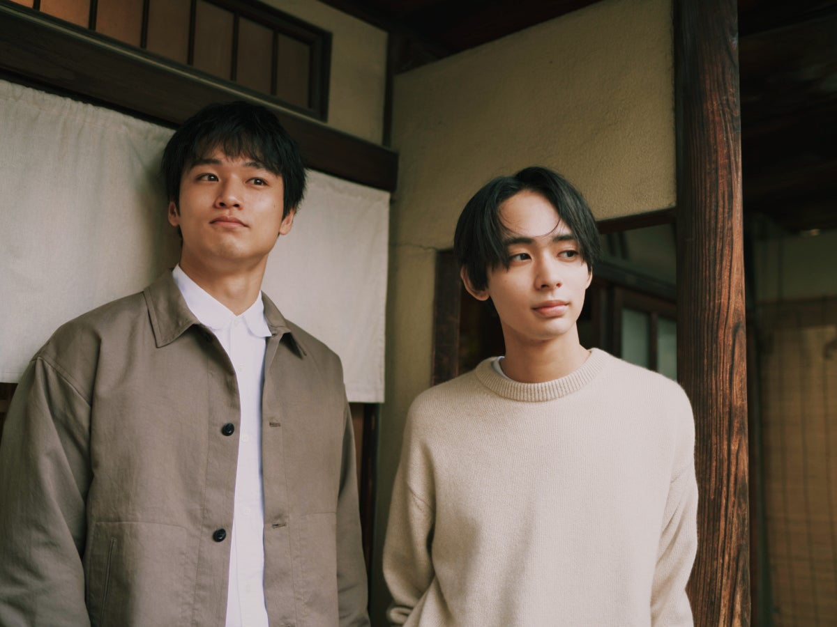 居酒屋の入り口前で佇む中川大輔と松井大奈