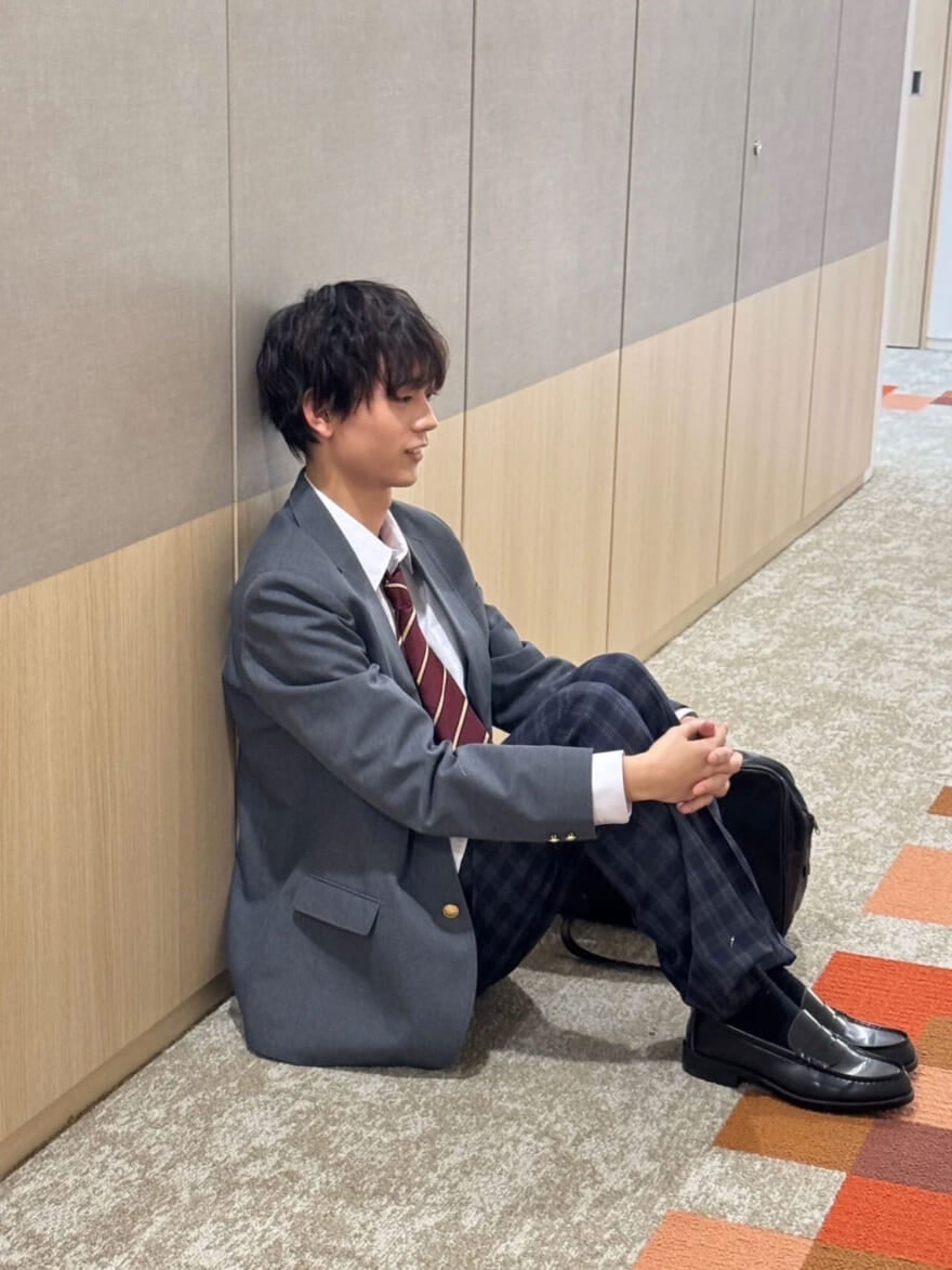 廊下に体操座りで座る制服姿のメンズノンノモデル水沢林太郎