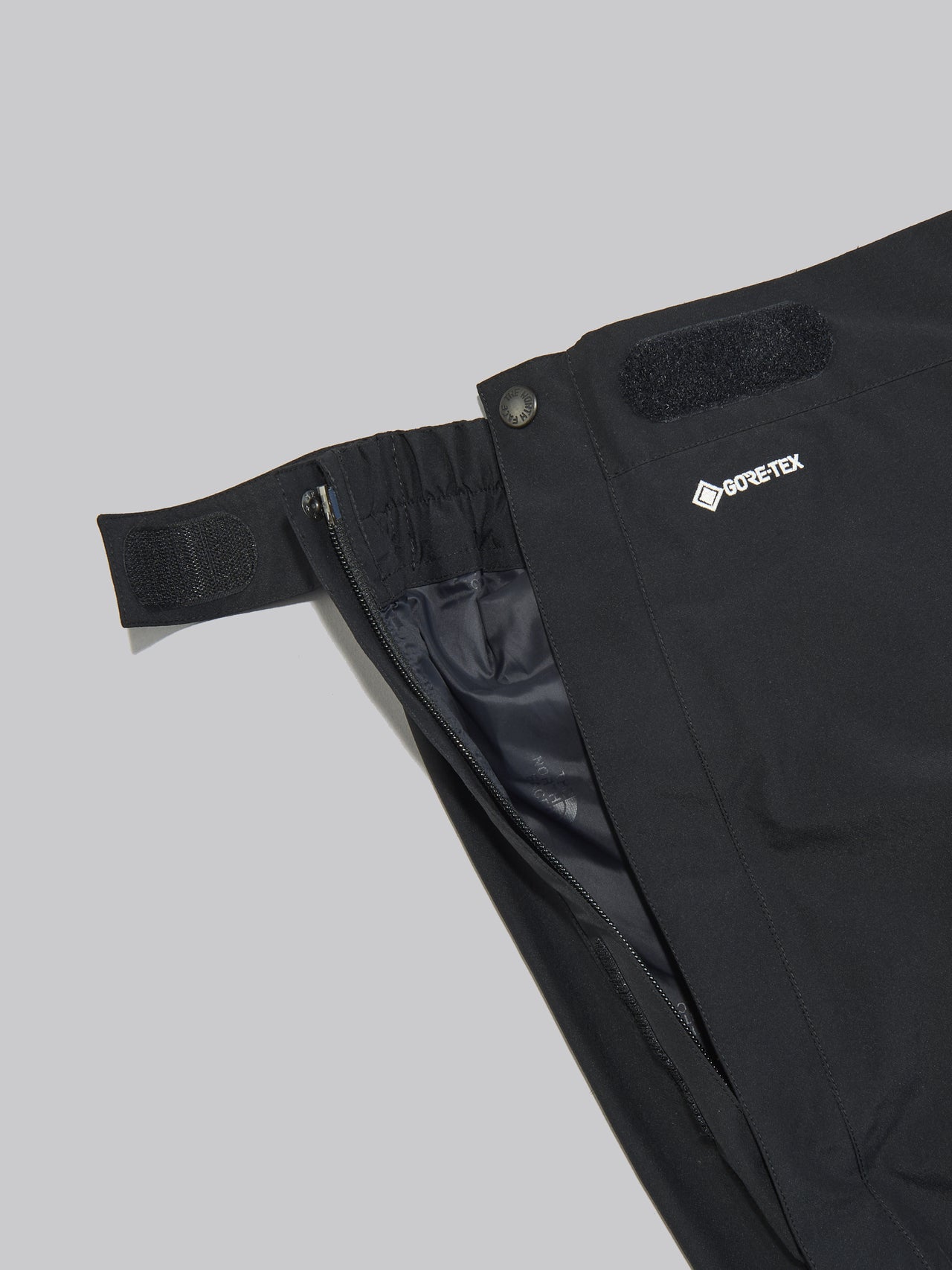 ザ・ノース・フェイスの黒い防水マウンテンパンツのスナップボタン、ジップ