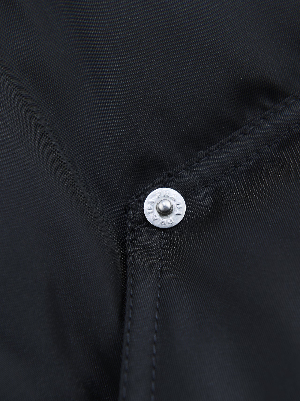 「プラダ」でこの冬押さえたい名作ダウンジャケット クロップド Re-Nylon ダウンジャケットのポケットのリベット