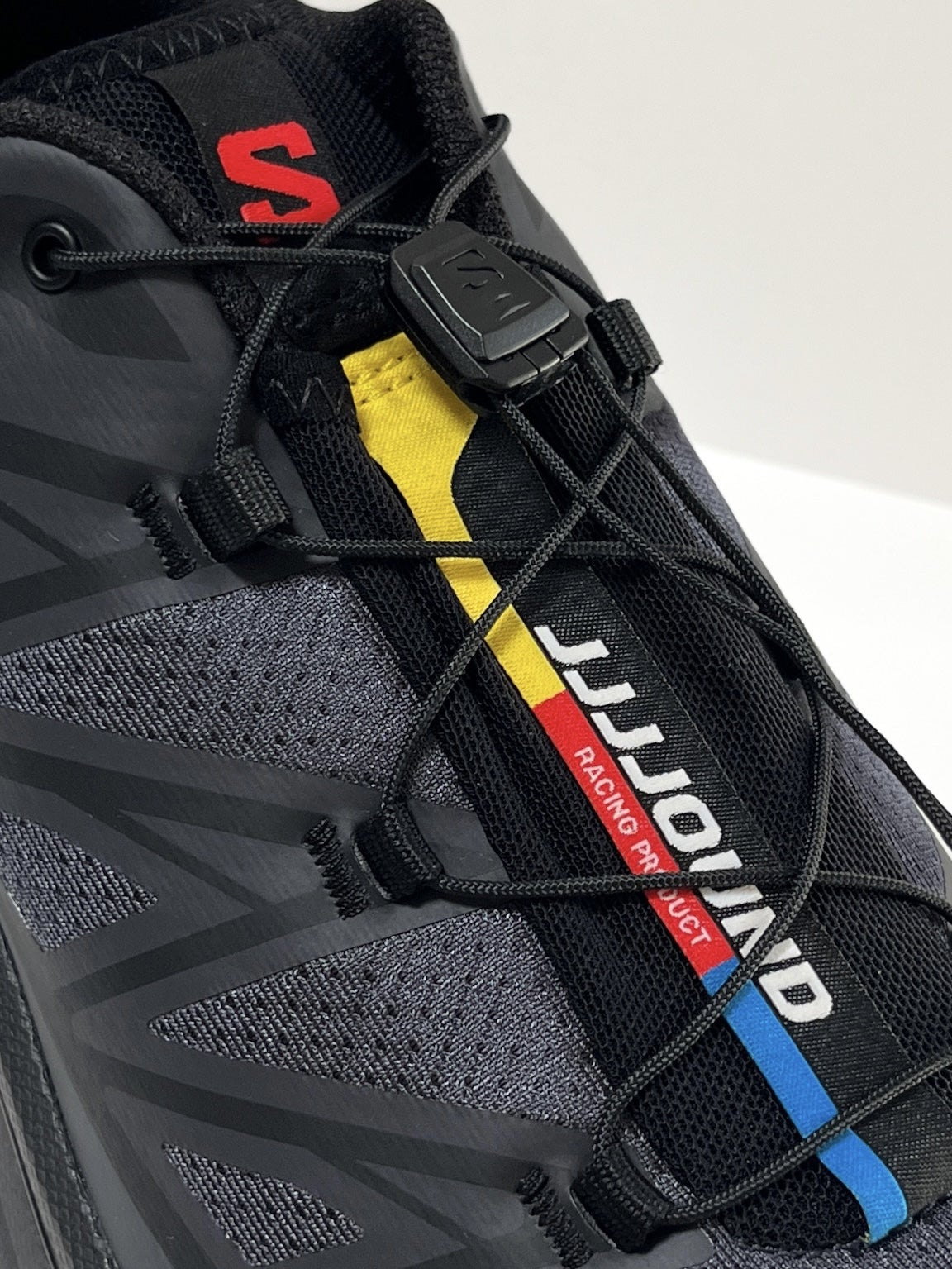 サロモンとジョウンド のコラボ黒スニーカーのタグ 寄り