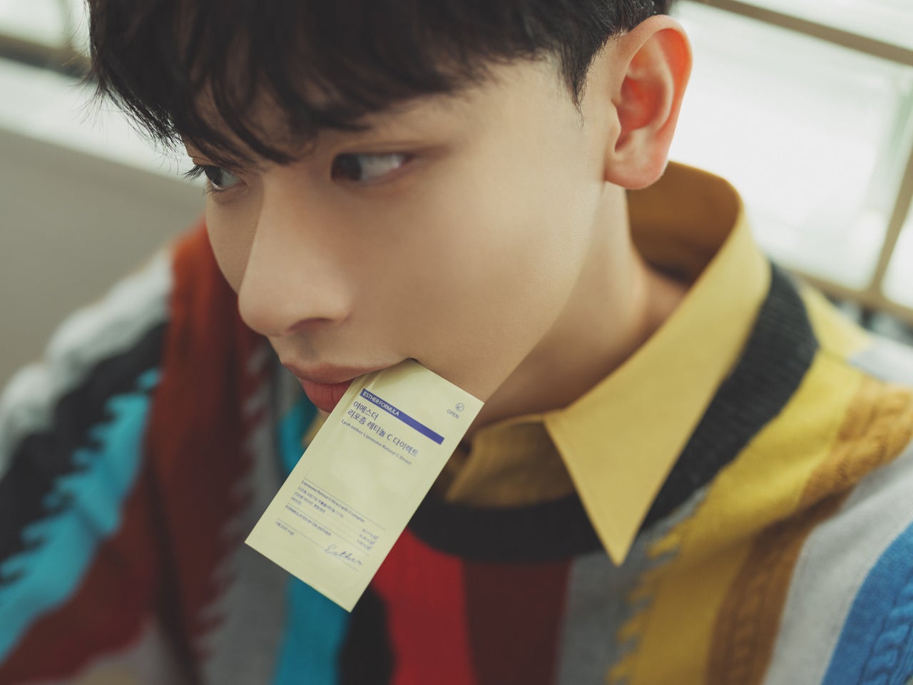 韓国「エスターフォーミュラ」のフィルム型サプリメントを口にくわえるよしあきさん