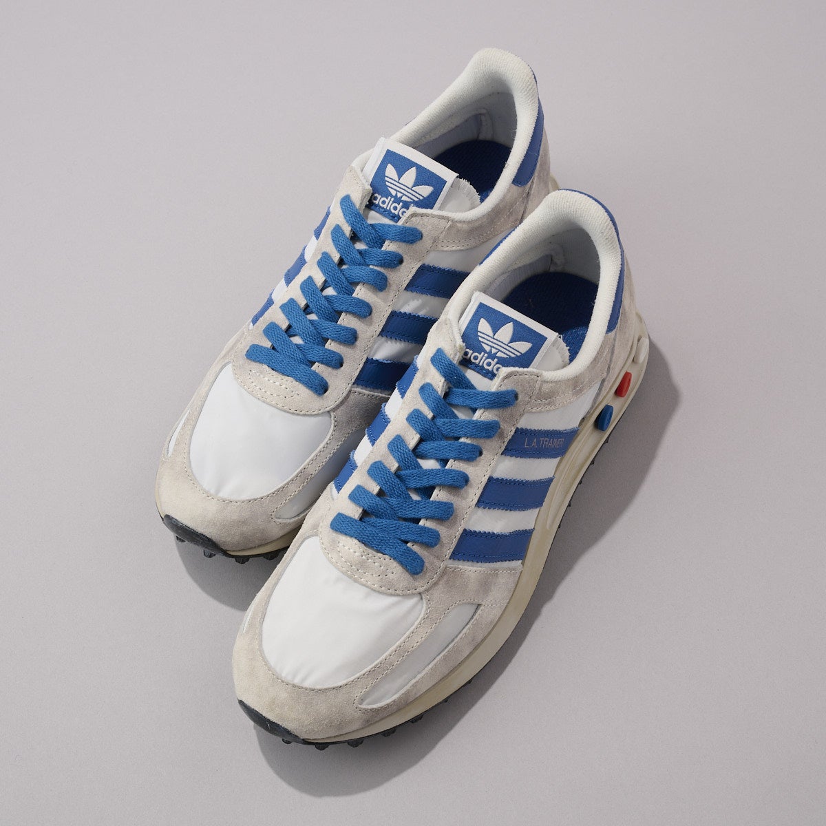 『アディダス』の白スニーカー／LA TRAINER OG