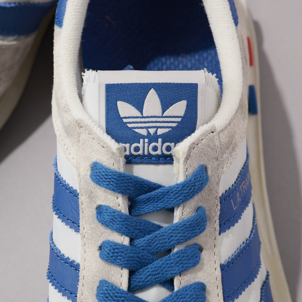 『アディダス』の白スニーカー／LA TRAINER OGのシュータン