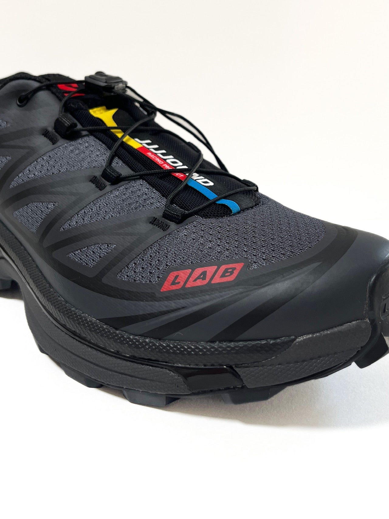 サロモンとジョウンド のコラボ黒スニーカーの爪先ロゴ