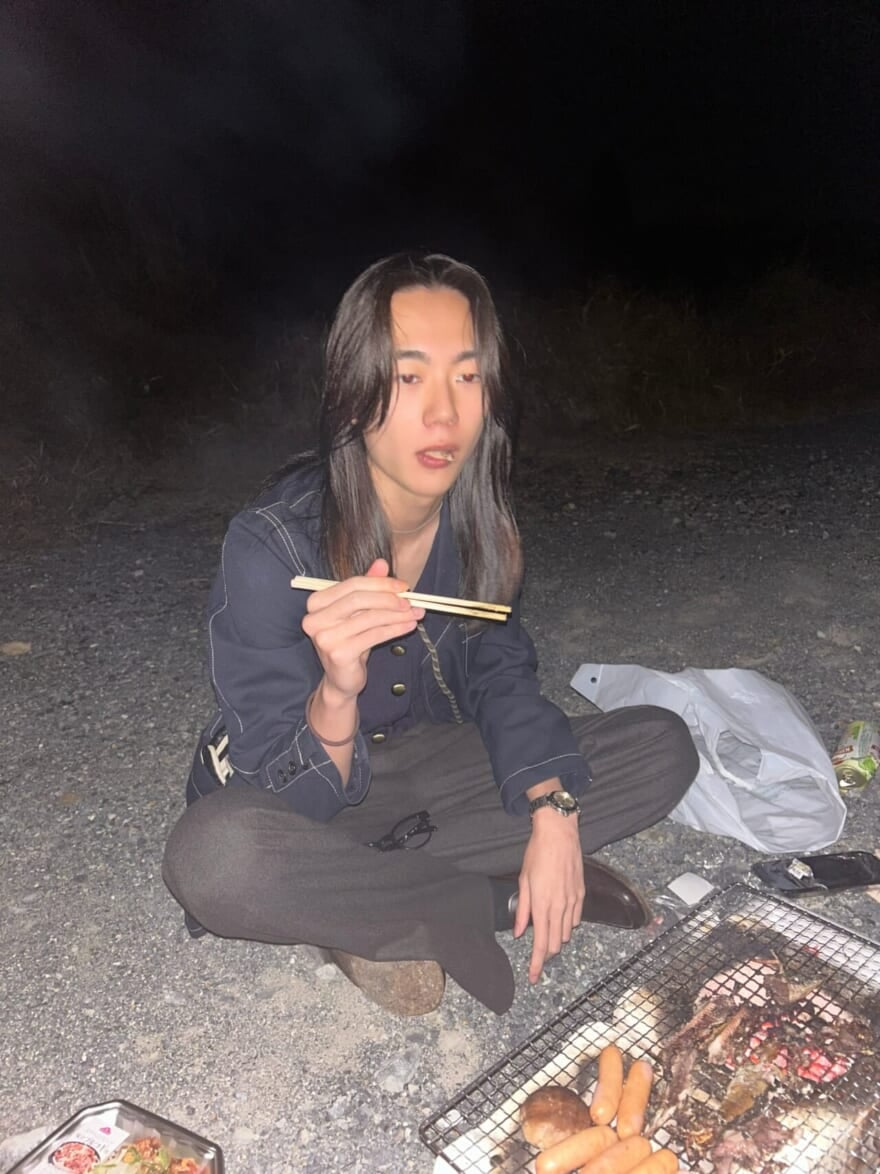 河原に座り、七輪で焼いた具材を食べるメンズノンノモデル籠宮壮太朗