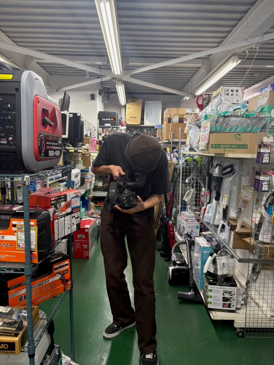リサイクルショップの店内でカメラを覗き込むメンズノンノモデル中田圭祐