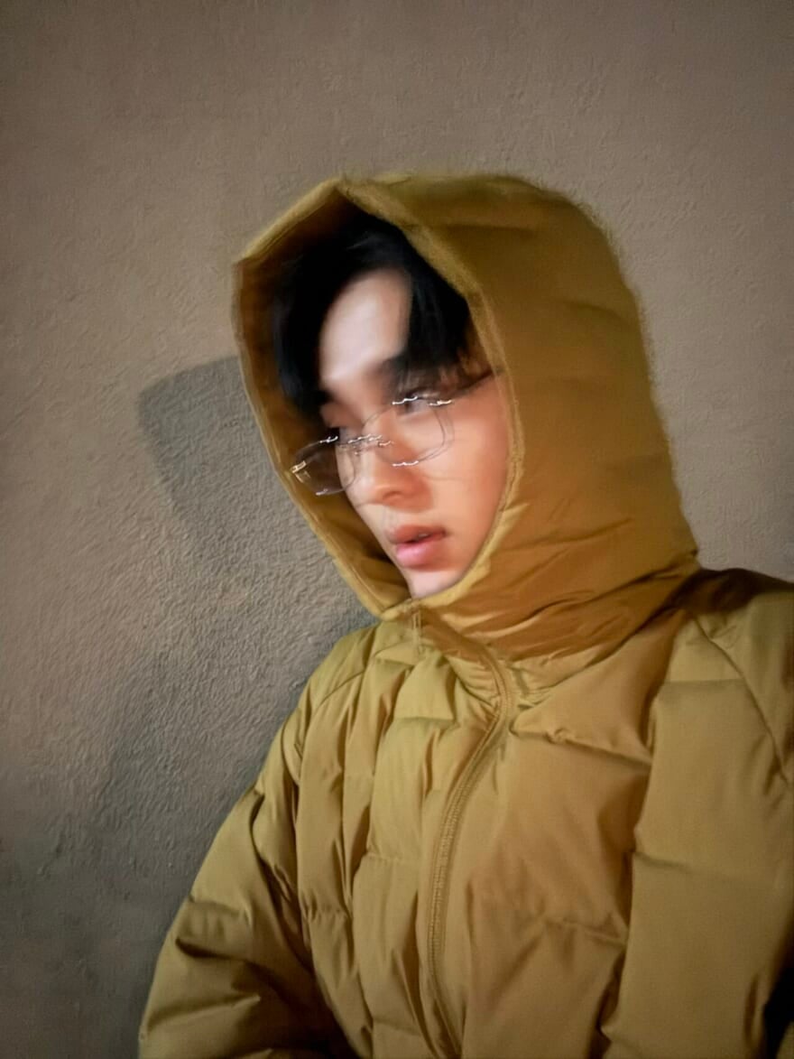 ダウンのフードをかぶる、メガネ姿の石川愛大