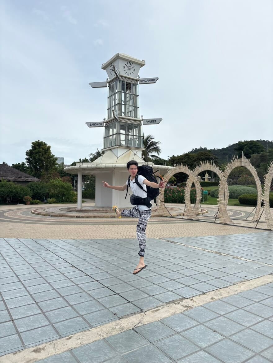 ジャンプするメンズノンノモデル栄莉弥。後ろには時計台が写っている。場所はタイ。