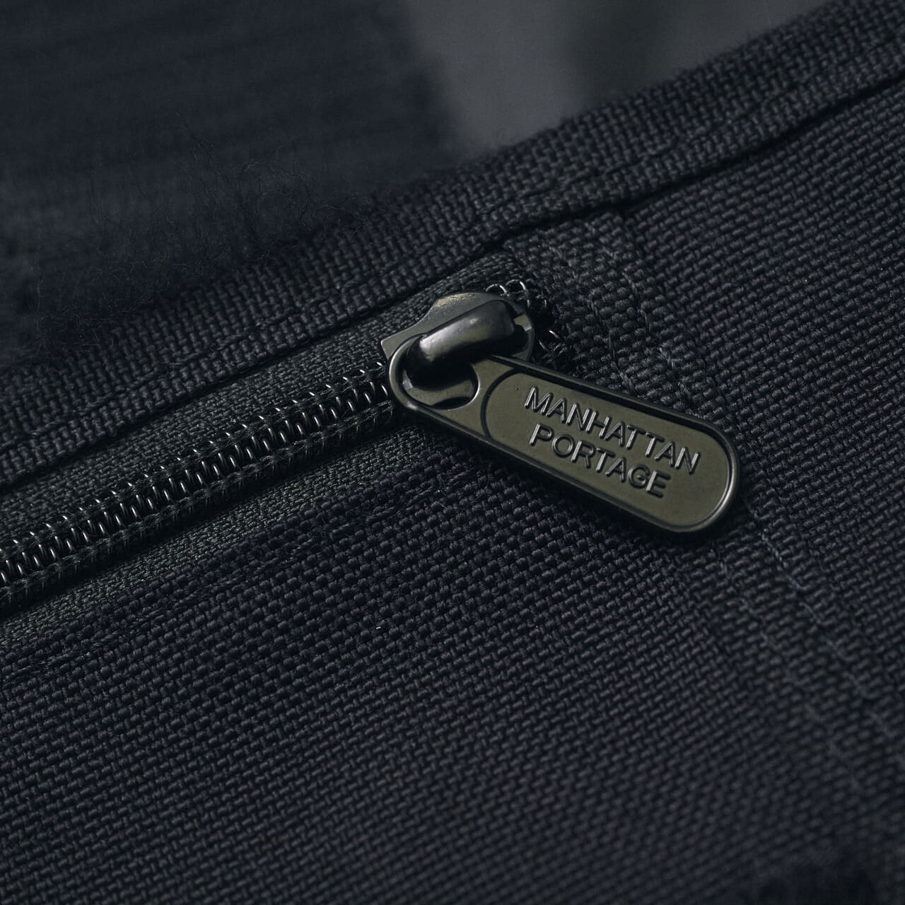 エディターが愛用すマンハッタンポーテージの黒いメッセンジャーバッグのファスナー